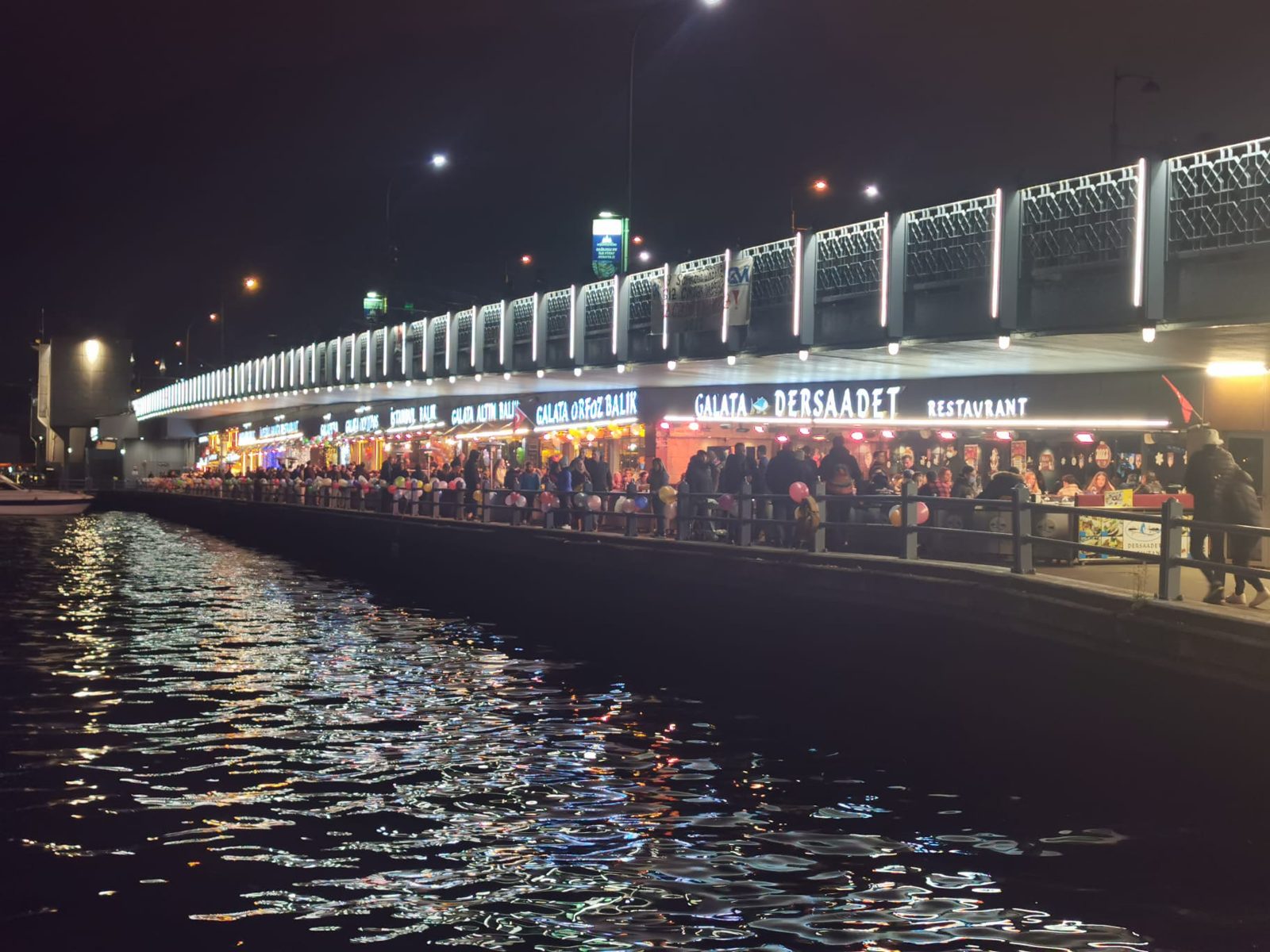 Die Restaurants unter der Brücke, abends hell erleuchtet