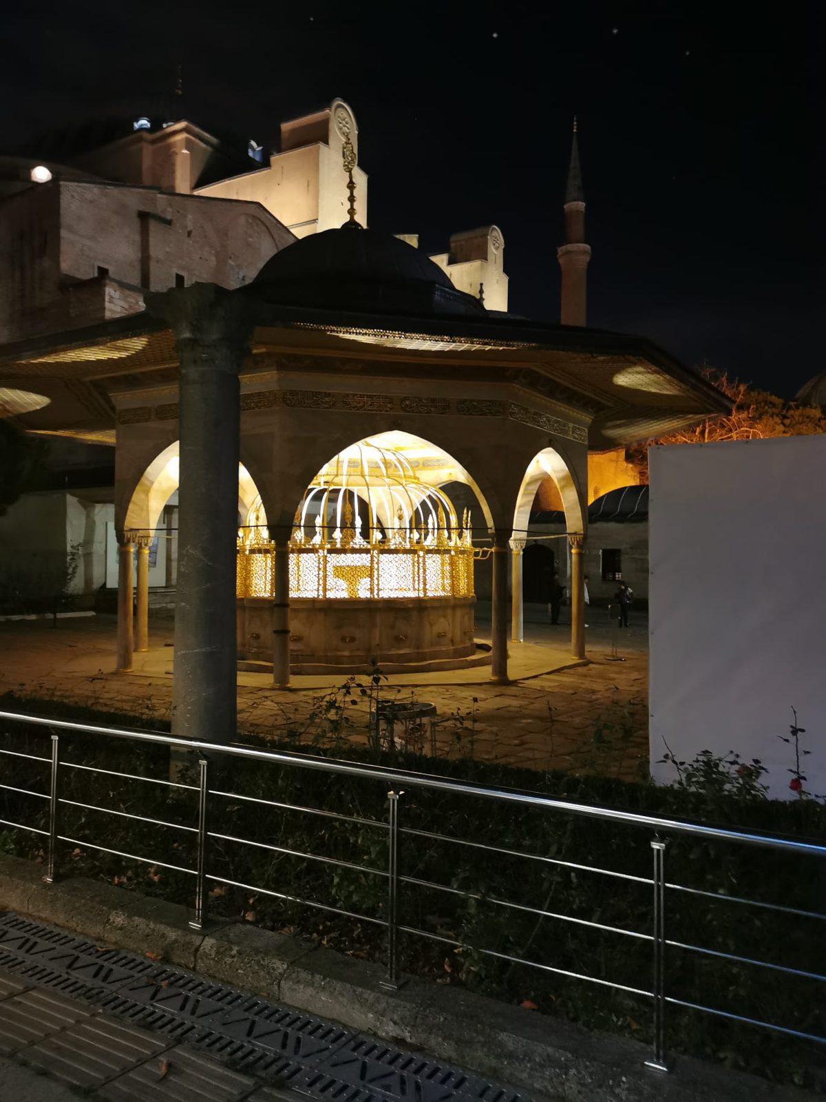 Der Brunnenpavillon im Hof, am Abend beleuchtet