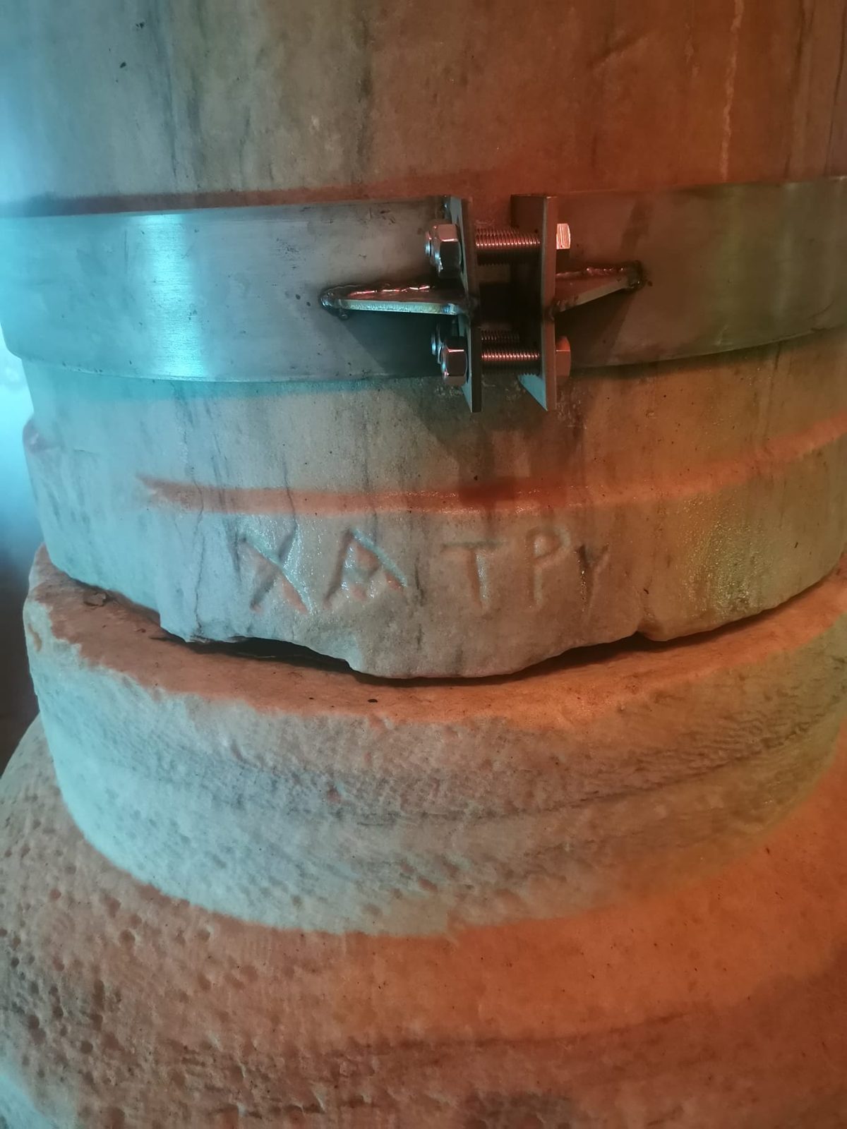 Eine Säule mit eingemeißelten Buchstaben und einer Eisenklammer